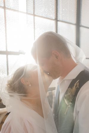 Bride and groom sharing a quiet moment beneath the veil during an intimate Utah wedding