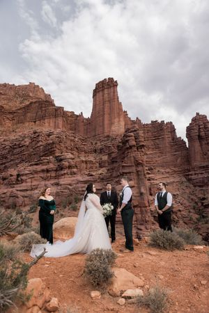 Elopement ceremony set against red rock cliffs during a Utah desert wedding