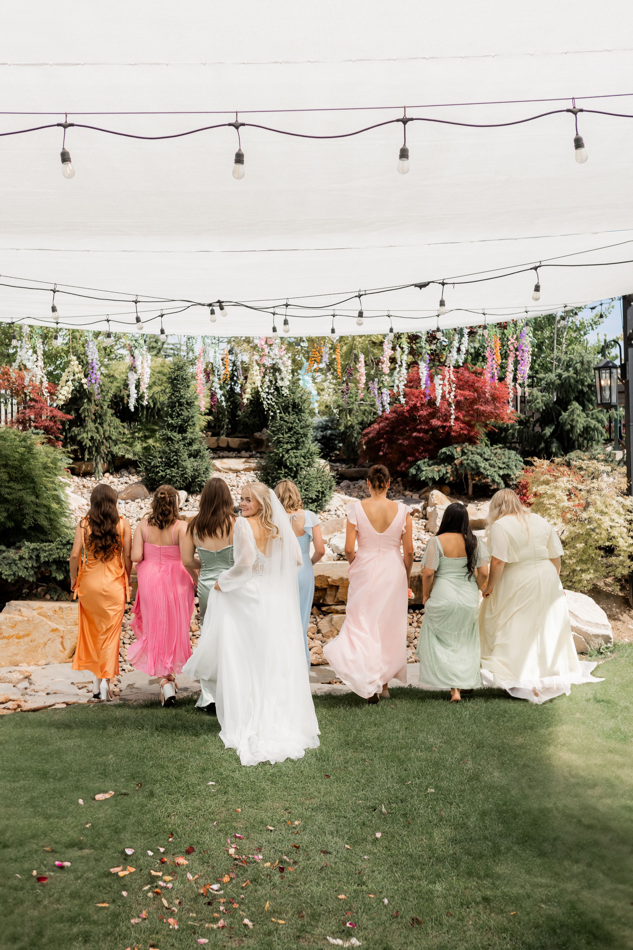 Bride walking with bridesmaids during a garden wedding celebration in Utah