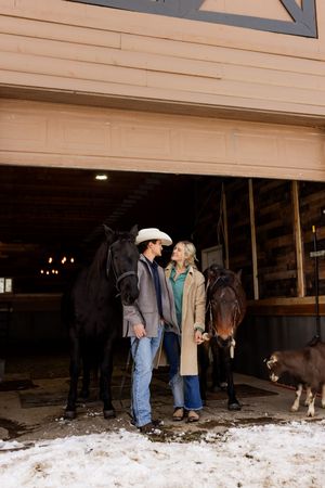 Couple holding hands inside a rustic barn during a winter couples session in Utah