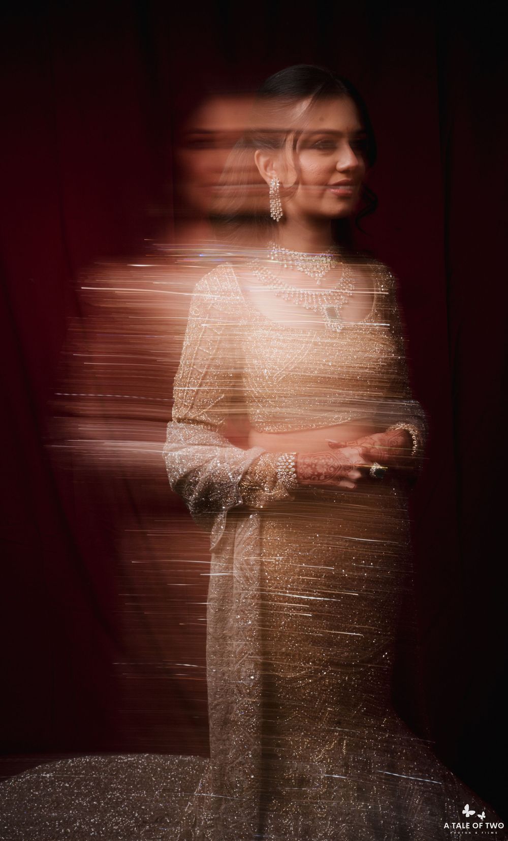 Artistic long exposure wedding photograph showing ethereal motion blur effect against dark background.