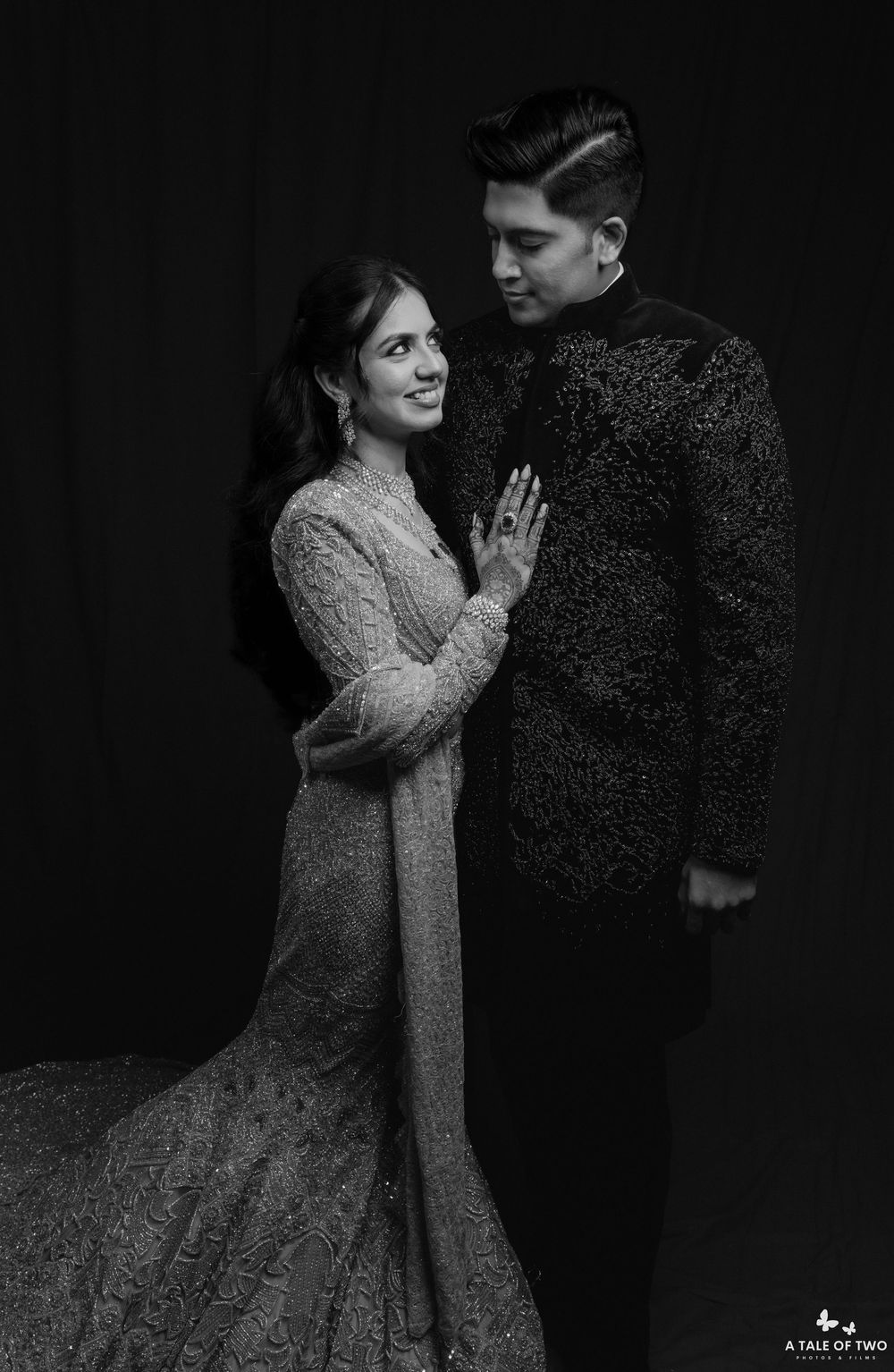 A dramatic black and white photo series shows a couple in vintage attire dancing together in an intimate moment.