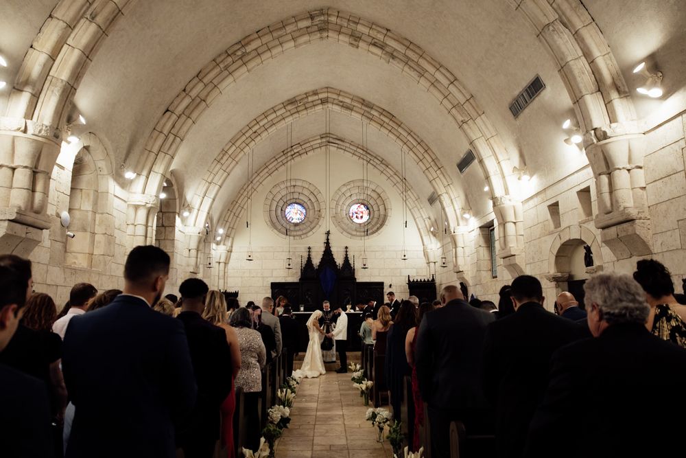Stone archways and vaulted ceilings create an elegant cathedral-like setting for a wedding reception.