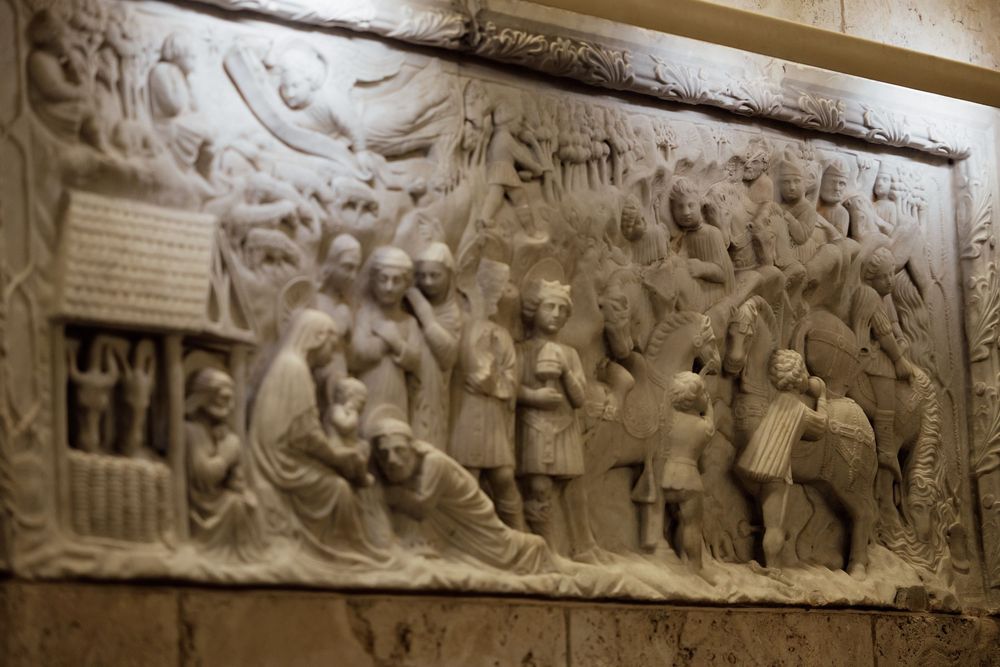 Ancient stone relief carving depicting multiple figures in a narrative scene.