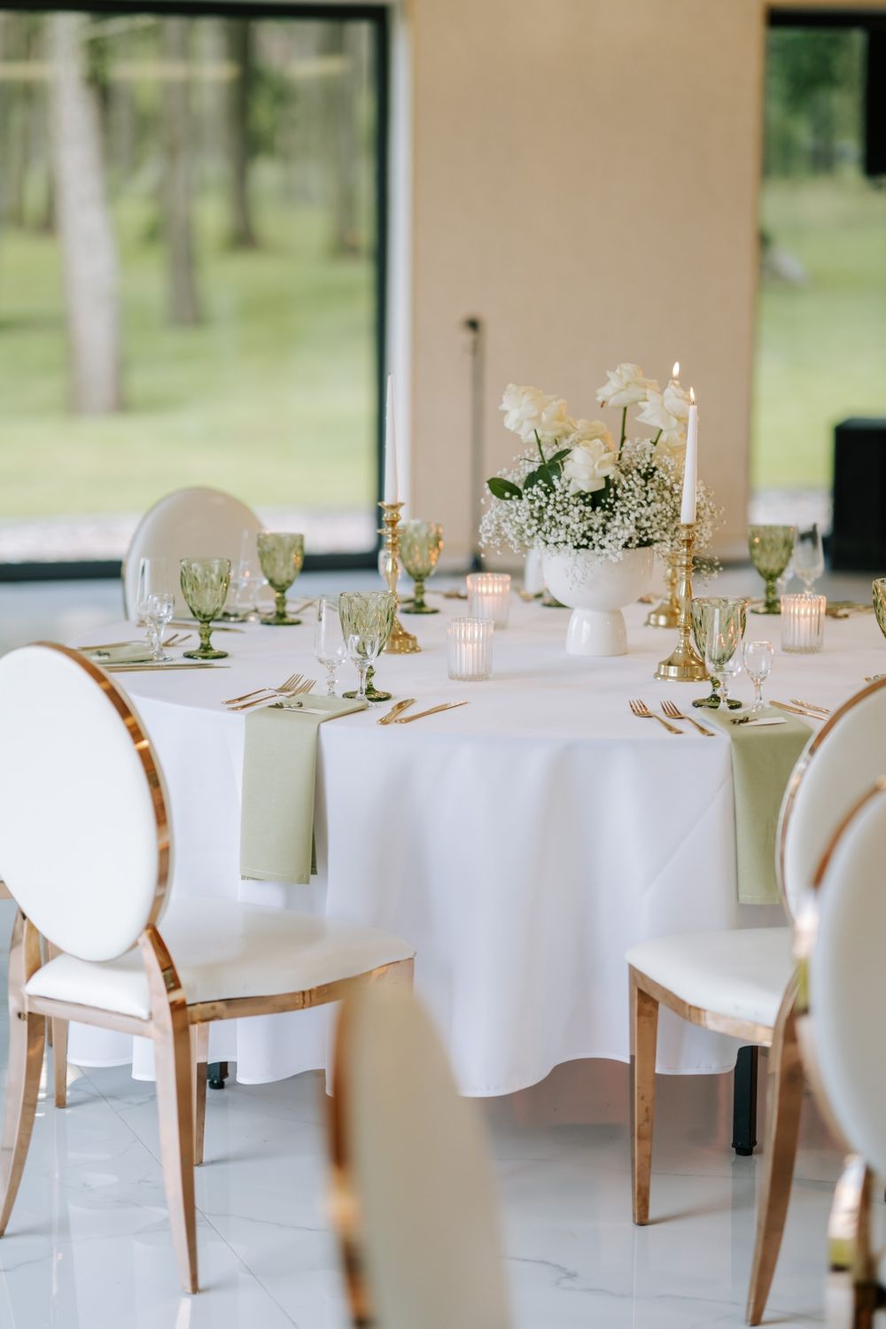 Sophisticated wedding reception table with white linens, gold accents, and floral centerpieces.