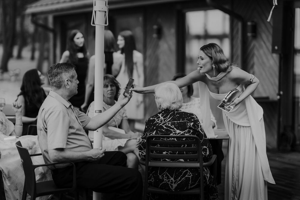 Black and white candid shots of wedding guests celebrating at an outdoor reception.