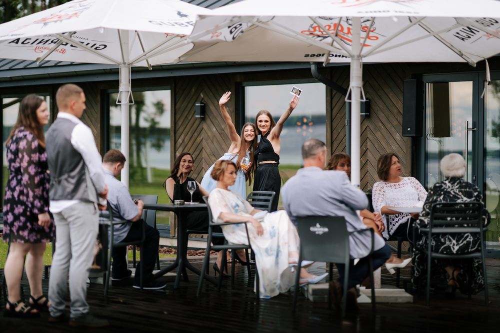 Wedding celebration at an outdoor cafe with white umbrellas and festive atmosphere.