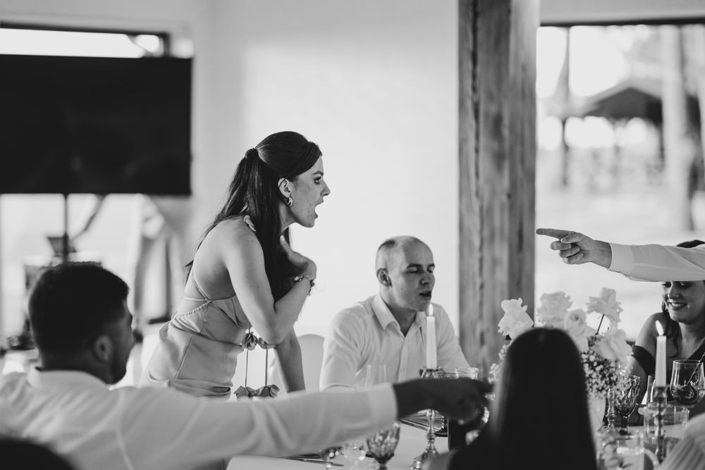 Black and white photo of guests engaged in conversation at an elegant dinner reception.