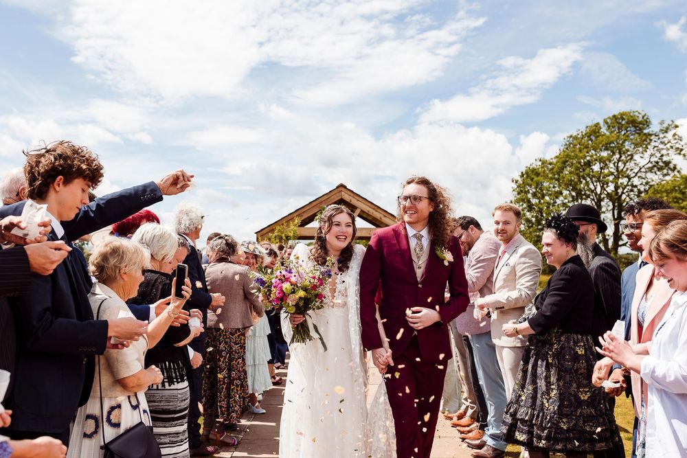 A sequence of wedding guests dancing in a line at an outdoor celebration, creating a festive atmosphere.