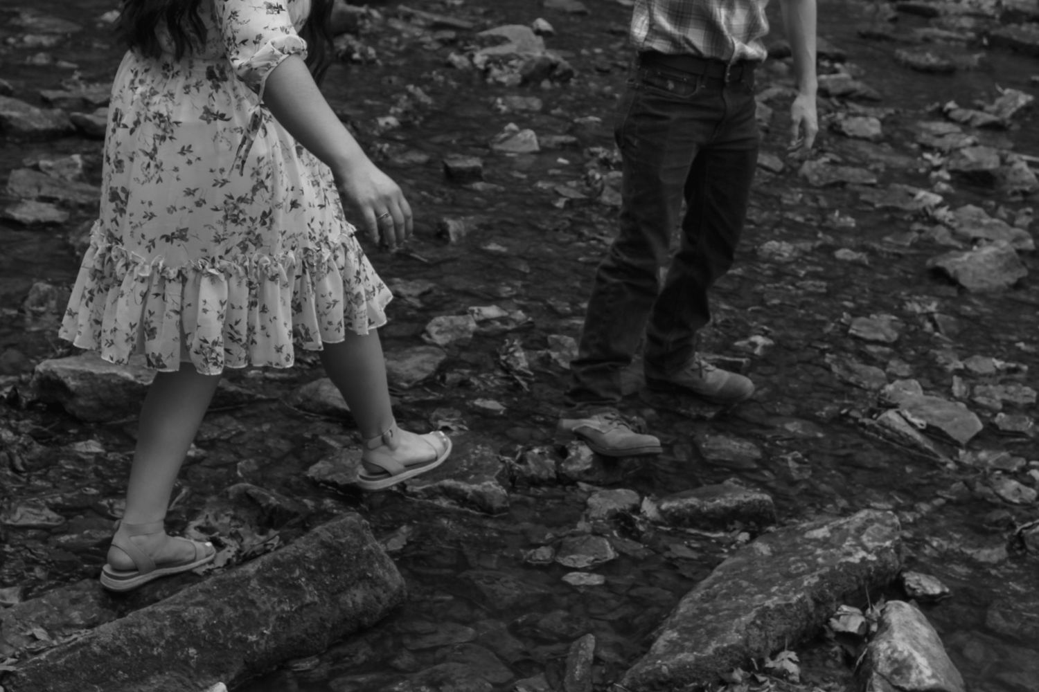 Series of feet walking on leaf-covered ground in black and white.