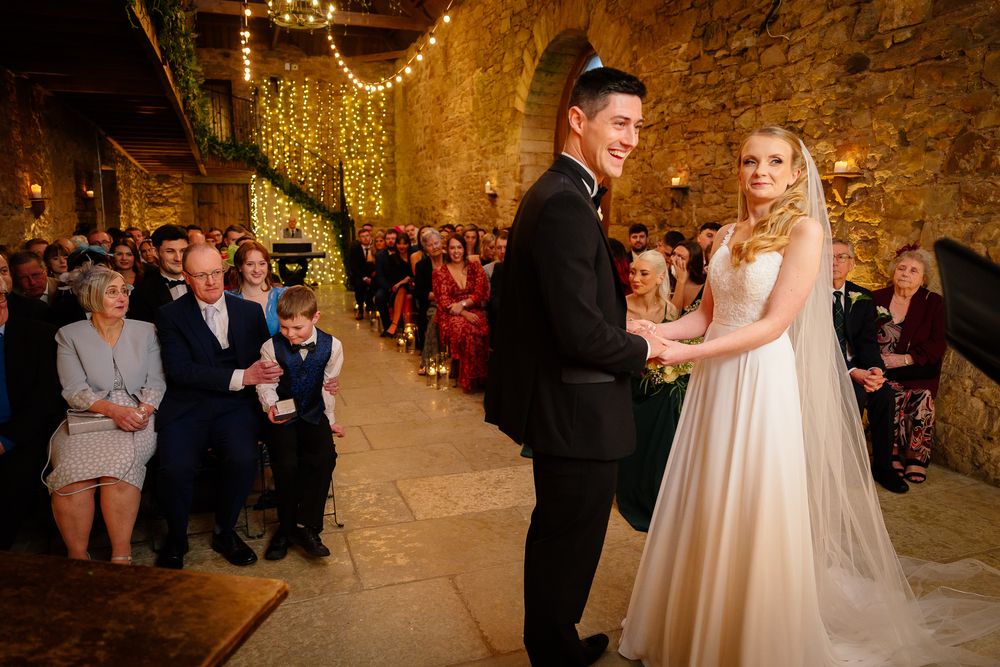 Wedding celebration in progress inside a historic stone building with warm ambient lighting.