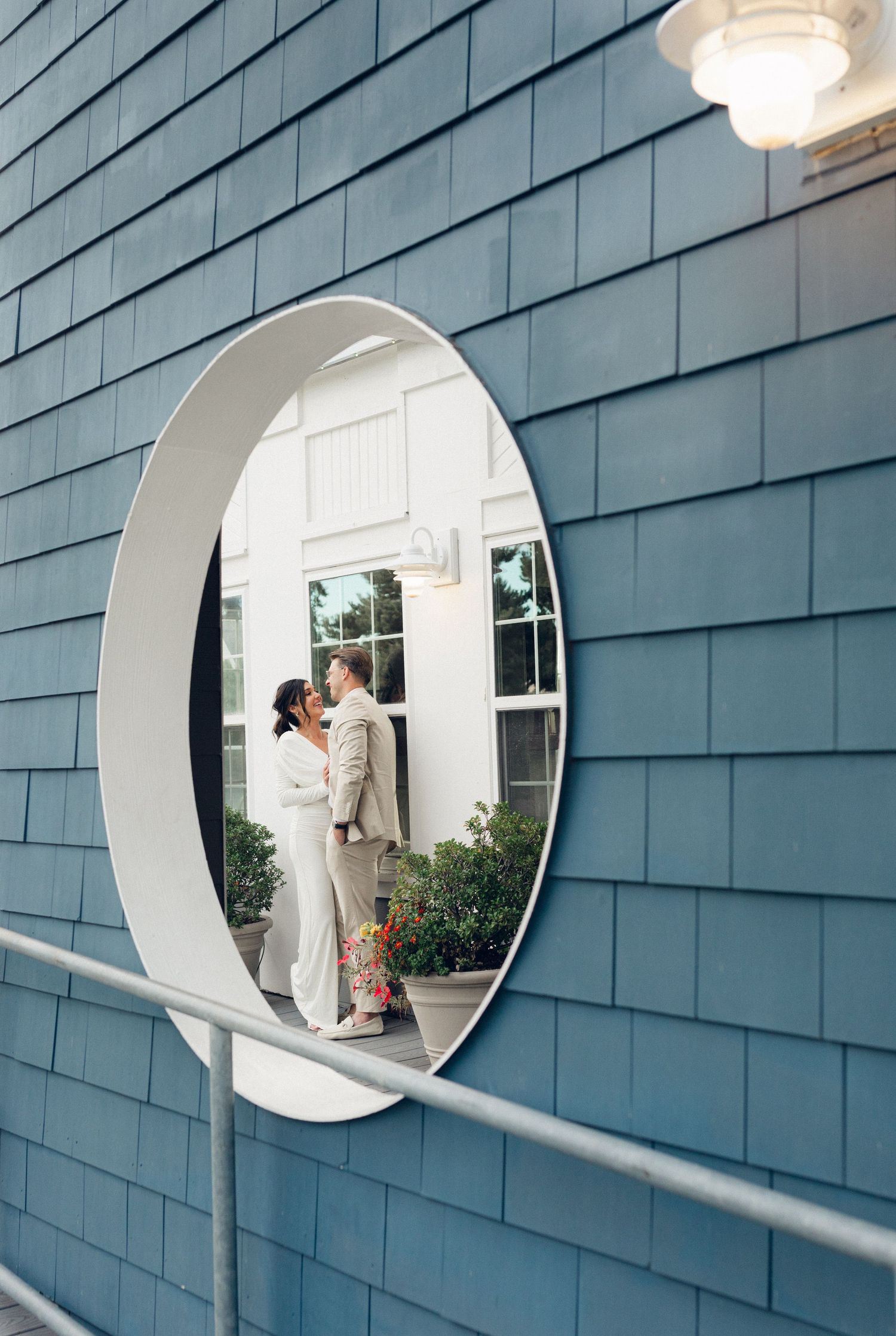 Three circular porthole windows on gray shingle siding create a modern architectural detail with white interior views.
