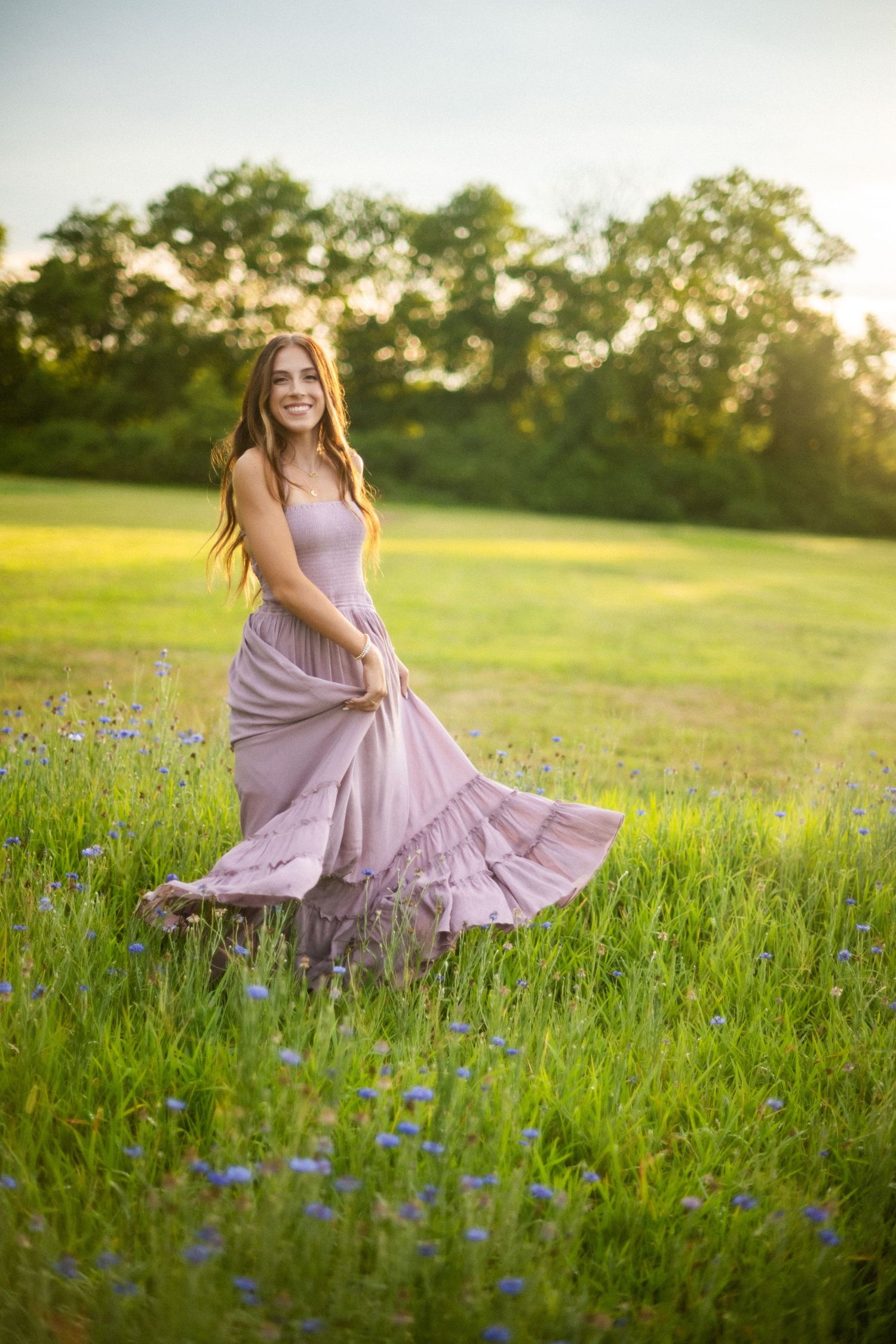 A person in a flowing lavender dress twirls gracefully in a sunlit meadow filled with vibrant wildflowers at golden hour.