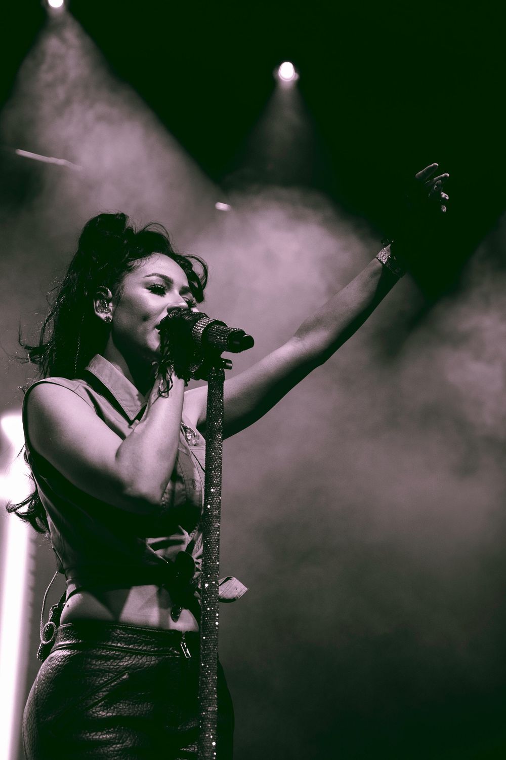Silhouetted performer on smoky stage with dramatic backlighting creating an atmospheric concert scene.