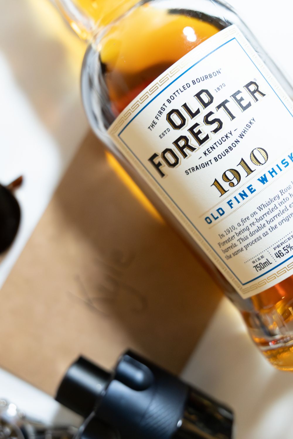Close-up view of Old Forester bourbon whiskey bottles in a row showing partial labels and amber liquid.