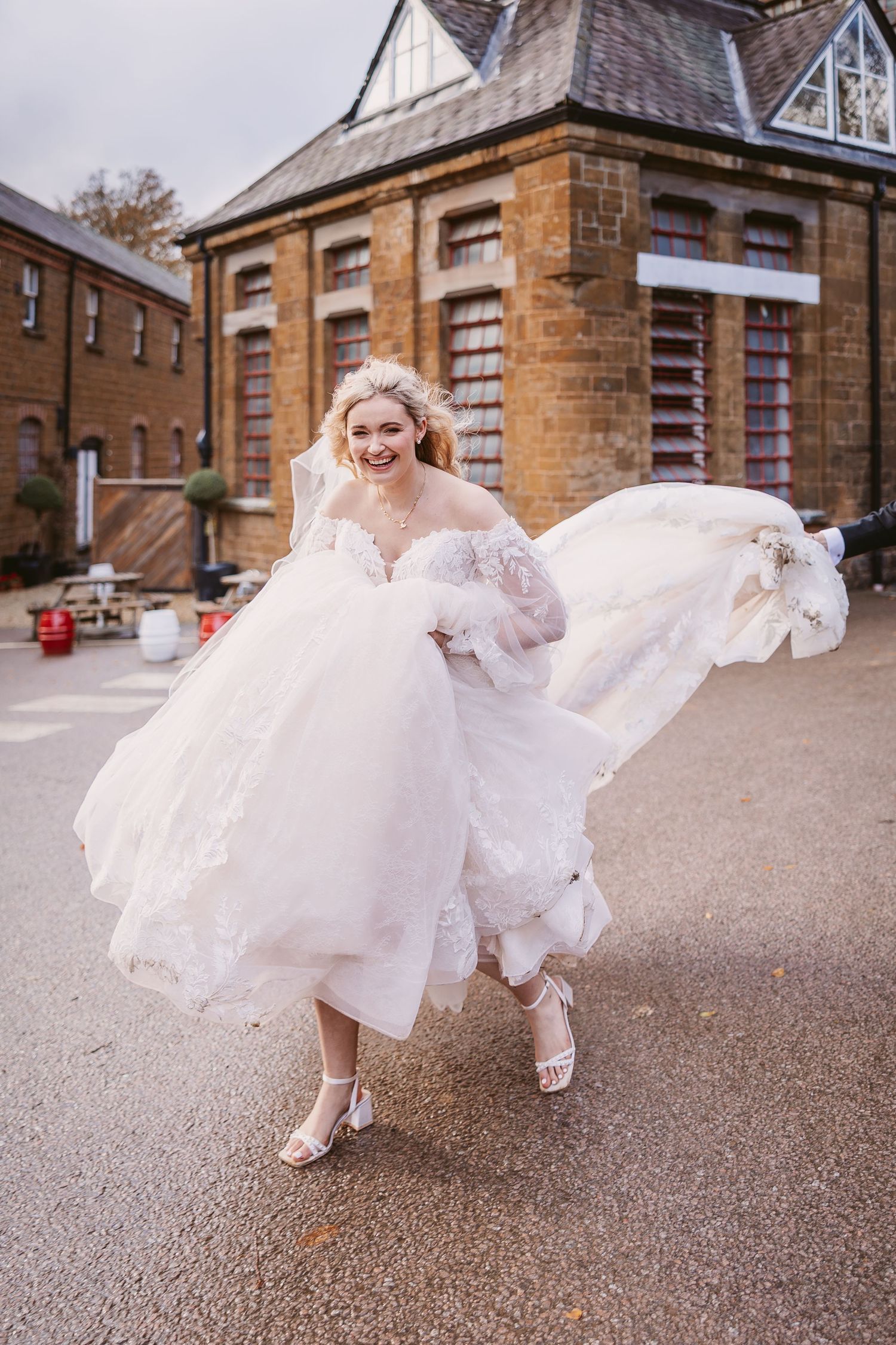A sequence of photos showing a white wedding dress flowing in the wind against a brick building backdrop.