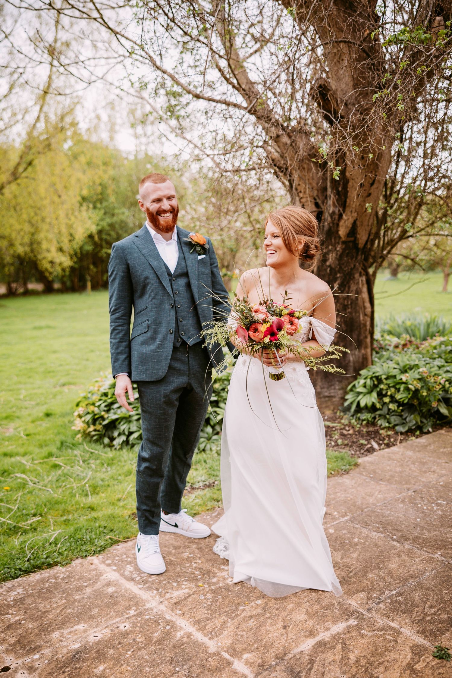 A couple shares a sweet moment together during their outdoor wedding photoshoot under blooming spring trees.