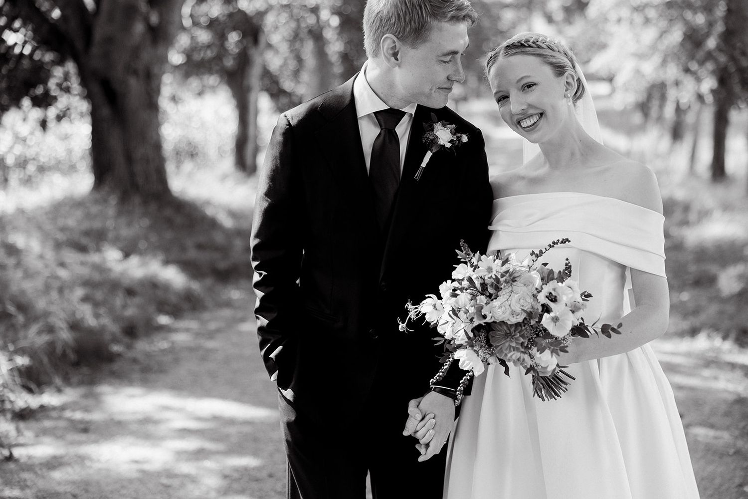 Black and white wedding photos show romantic moments between newlyweds in an outdoor garden setting.