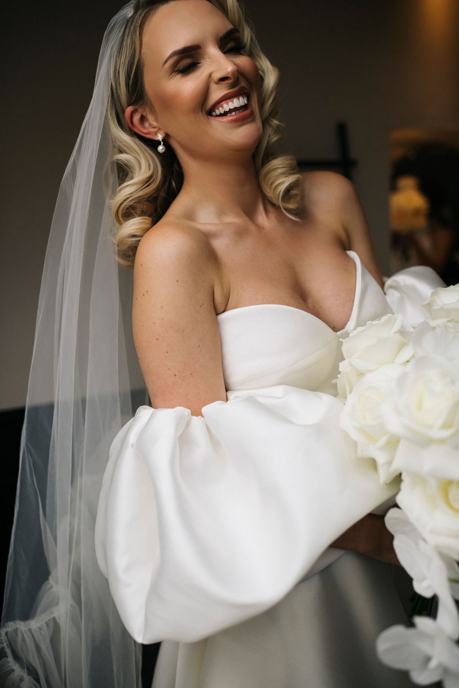 A joyful wedding celebration with white confetti falling as newlyweds walk down stone steps in formal attire. Editorial wedding photographer
