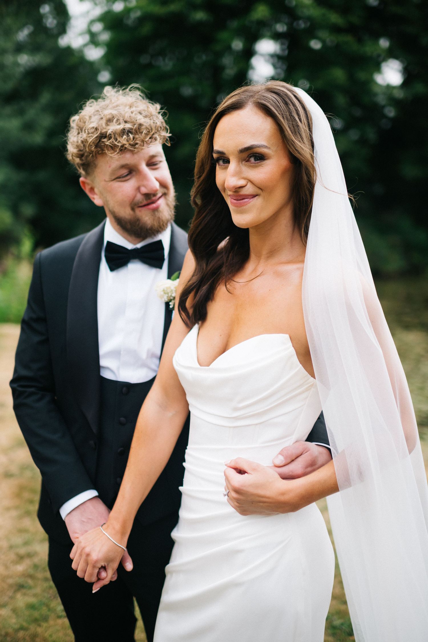 A series of four artistic wedding photos showing a bride posing against a rustic stone wall in a flowing white gown. Hidden River Cabins.