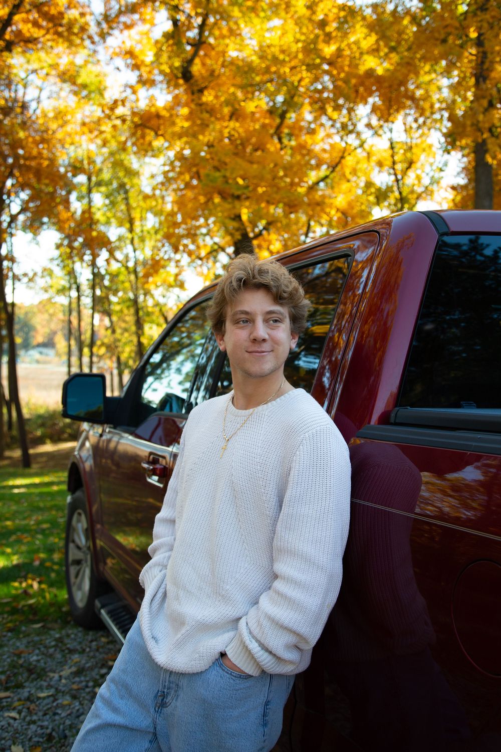 Michigan senior fall photo shoot in woods with bright true to color editing with his truck