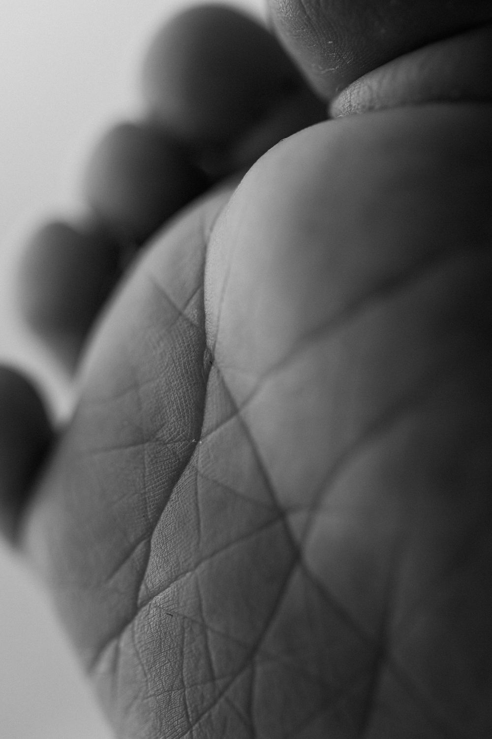 A sequence of black and white macro photographs showing textural details of baby's feet.
