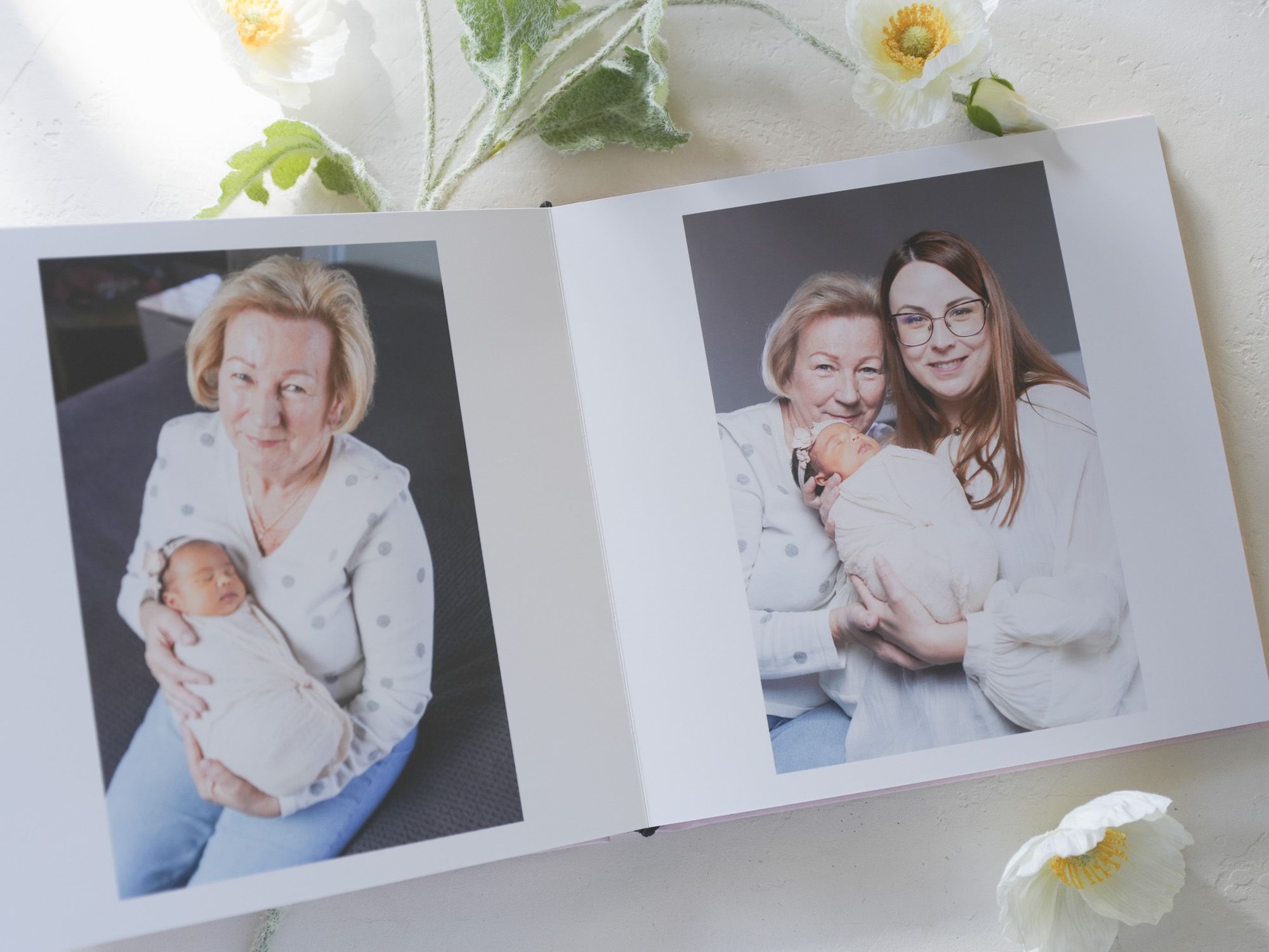 Photo album spread featuring tender moments between family members in white outfits.