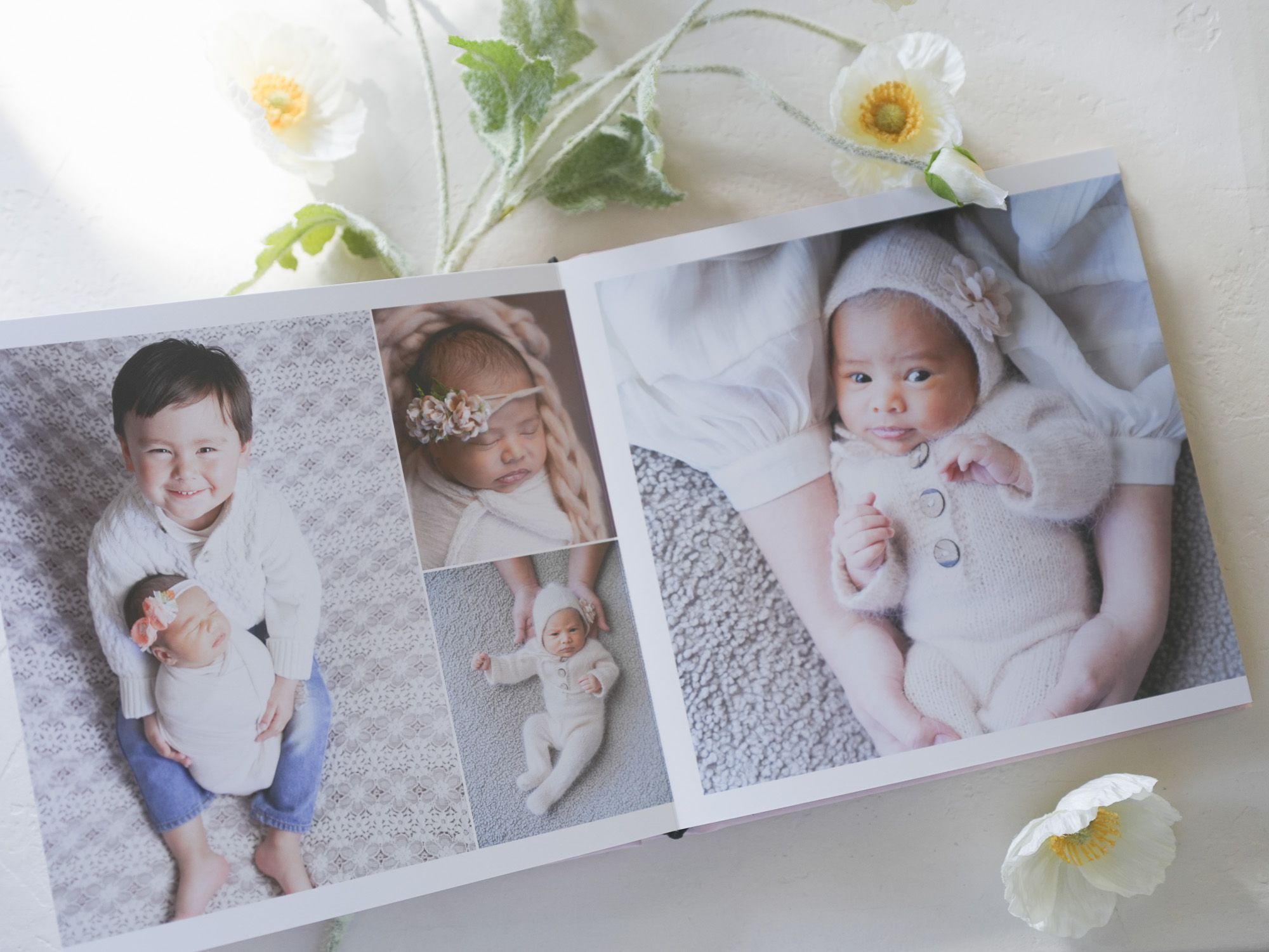Baby photo album spread featuring adorable infant portraits on textured backgrounds.