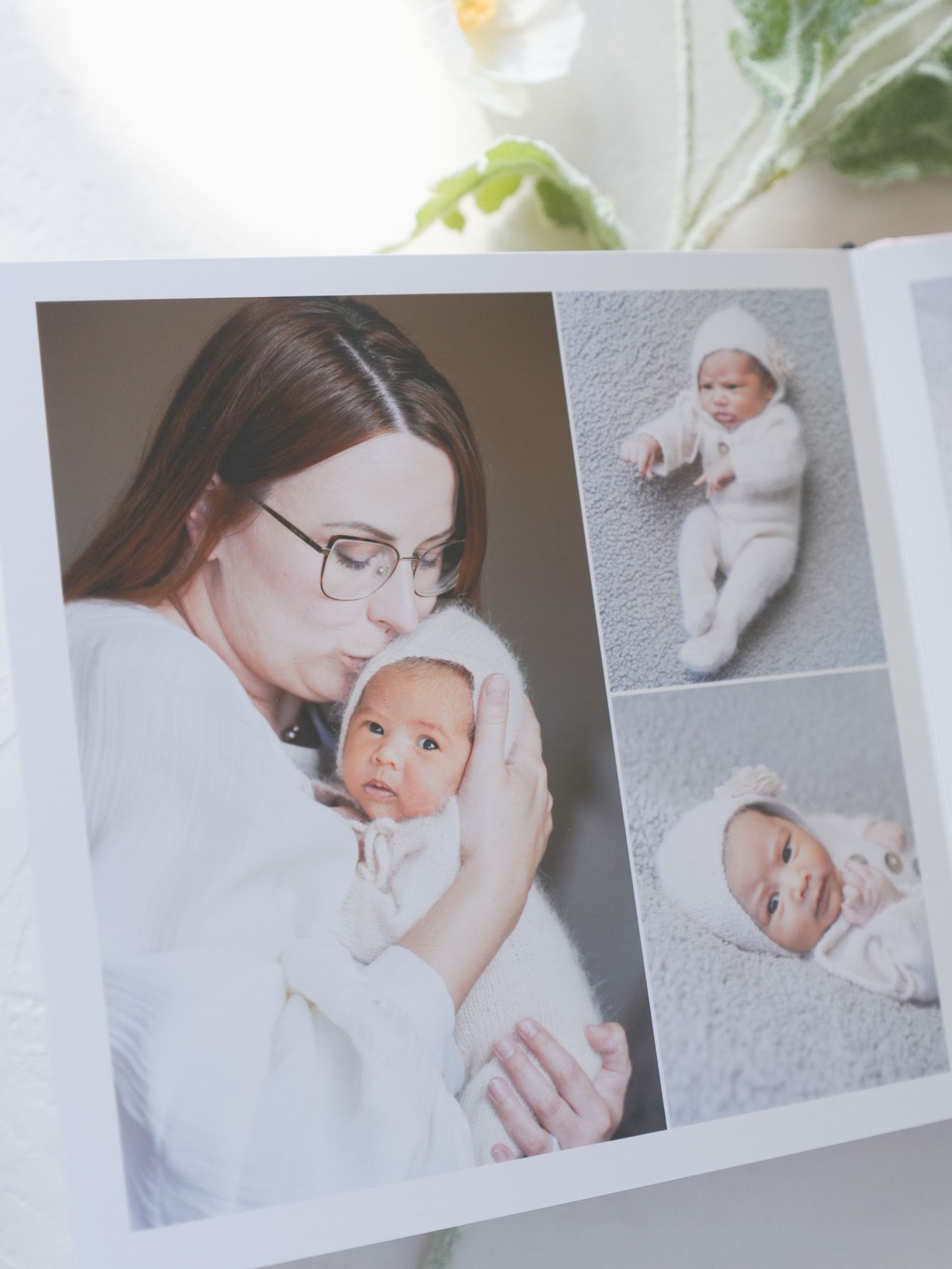 Photo album spread showing tender parent-child moment alongside infant portraits.