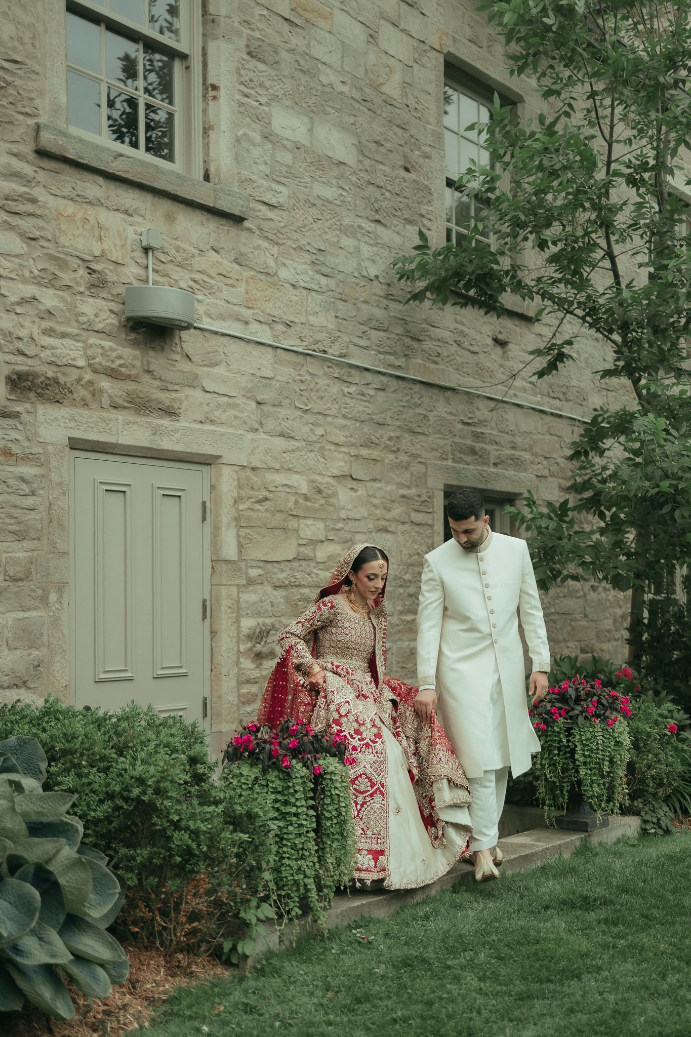 A tender wedding moment captured outside an elegant venue with warm lighting.