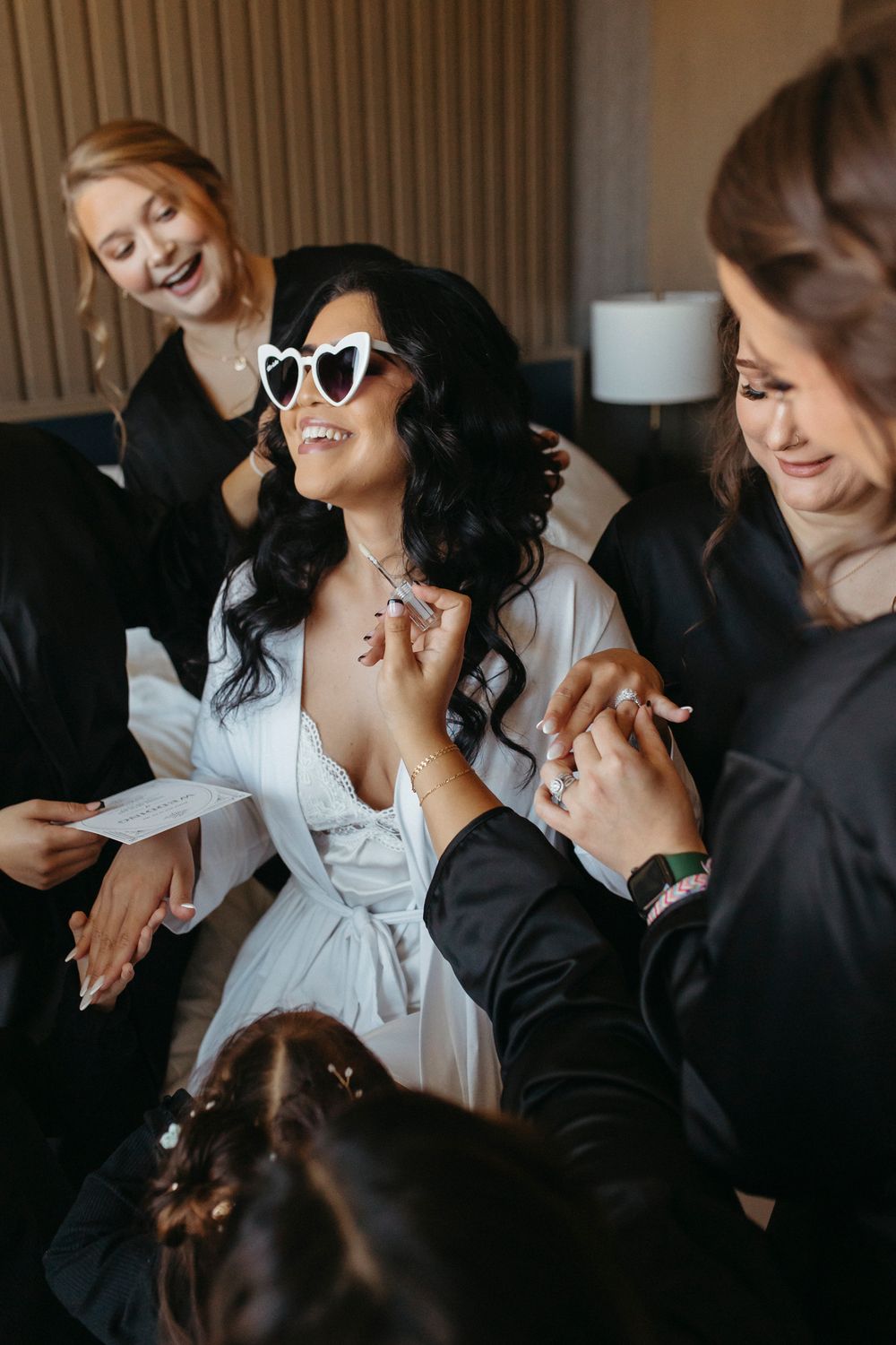 Joyful pre-wedding celebration with heart-shaped sunglasses and laughter.