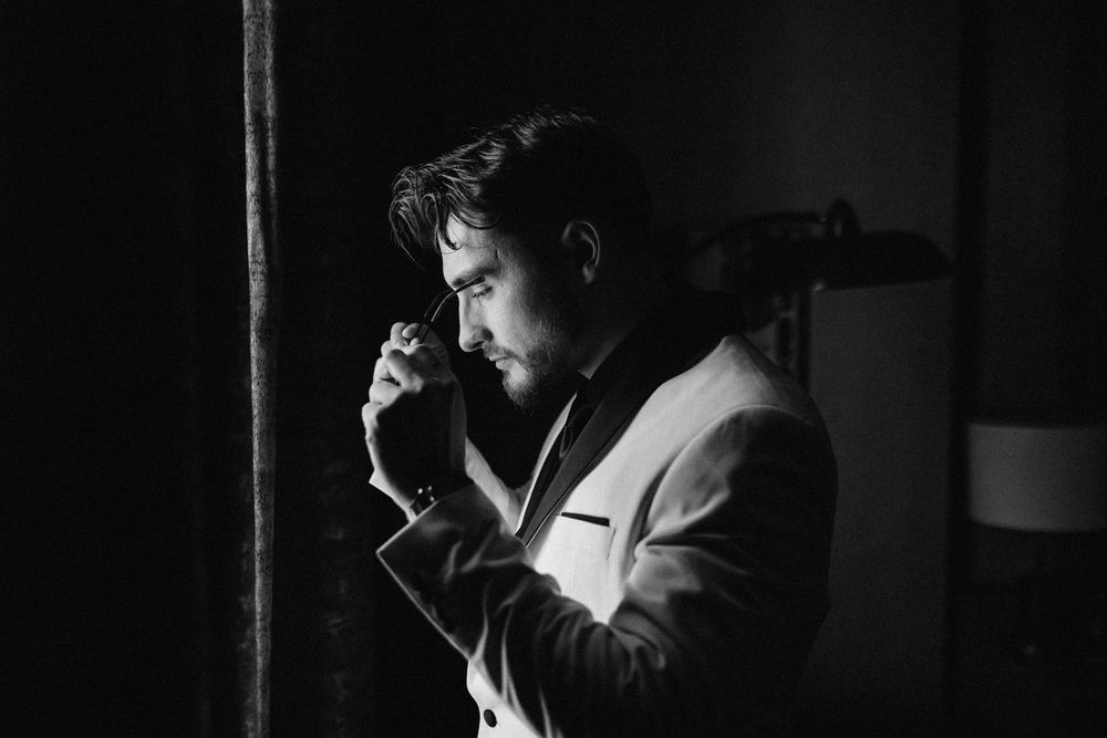 Moody black and white portrait of person in formal attire looking contemplative.