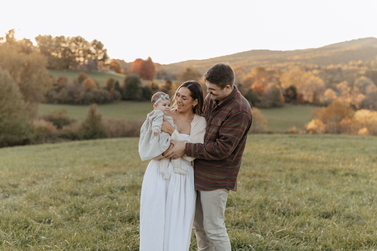 A heartwarming family moment captured in a rustic autumn field at golden hour.