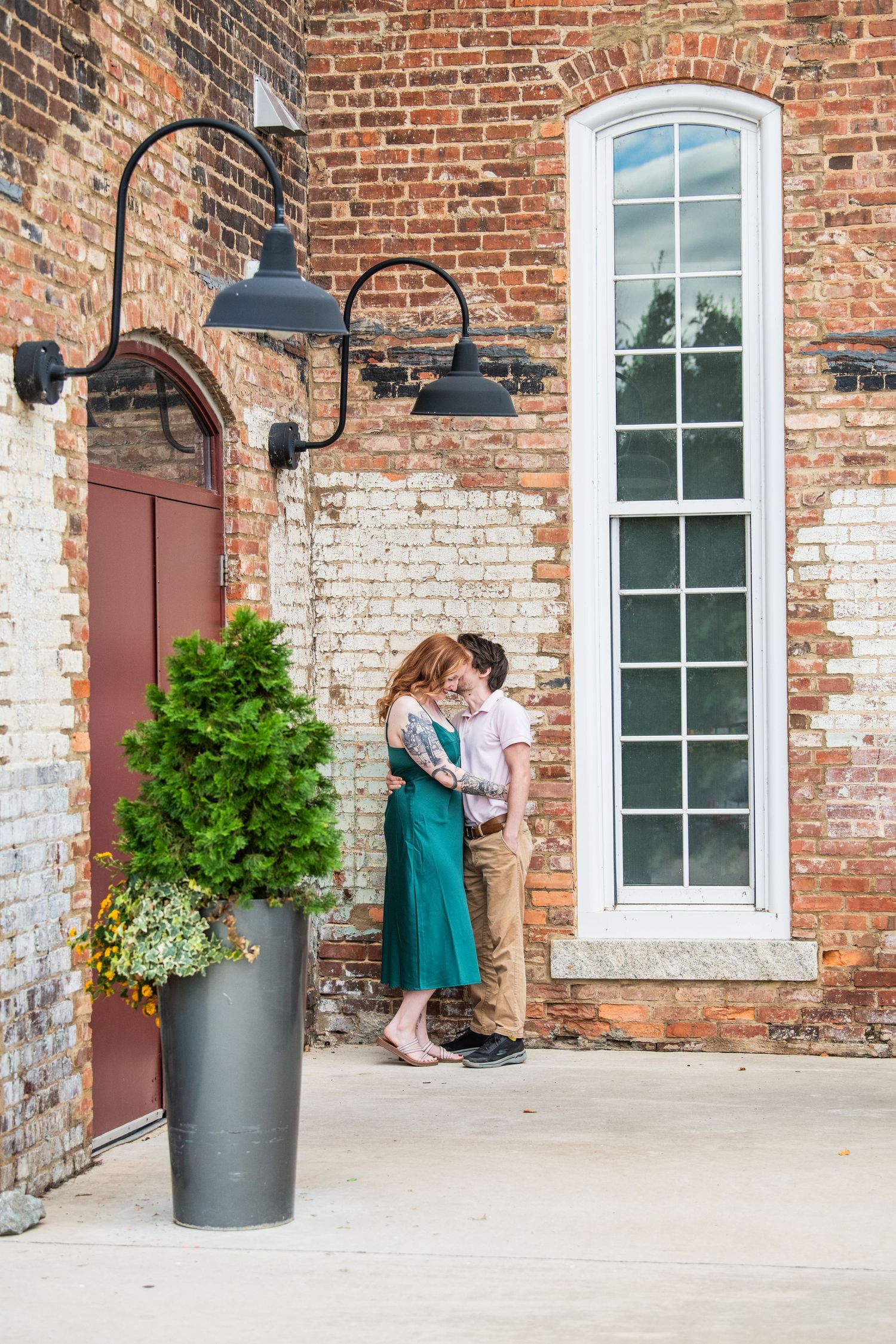 A beautiful couple saying 'Yes' to each other in the stunning rustic industrial setting of Revolution Mill, capturing timeless engagement mo