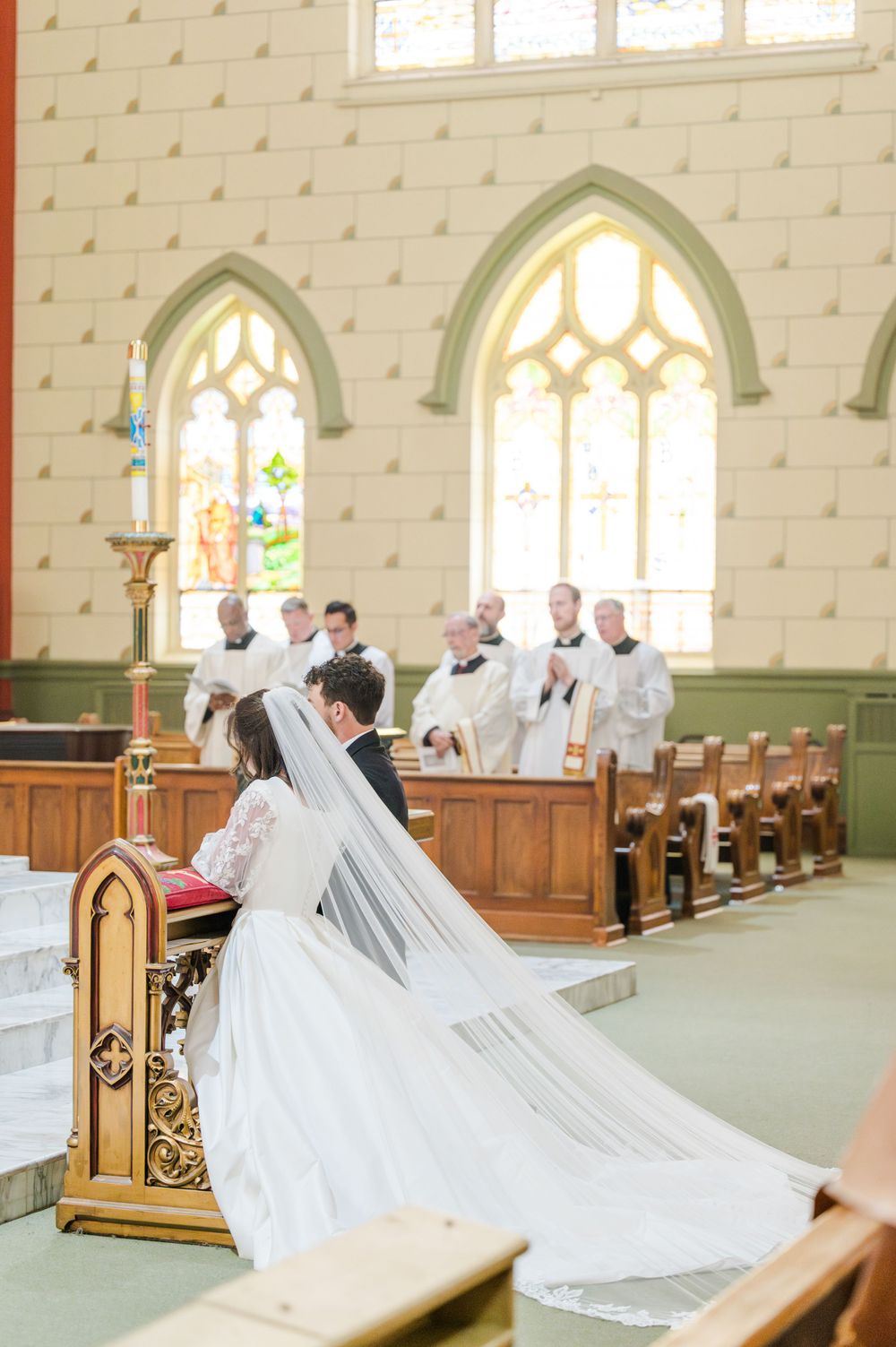Bride and groom kneeling during their Traditional Latin Mass wedding at Holy Family Cathedral in Tulsa, Oklahoma.