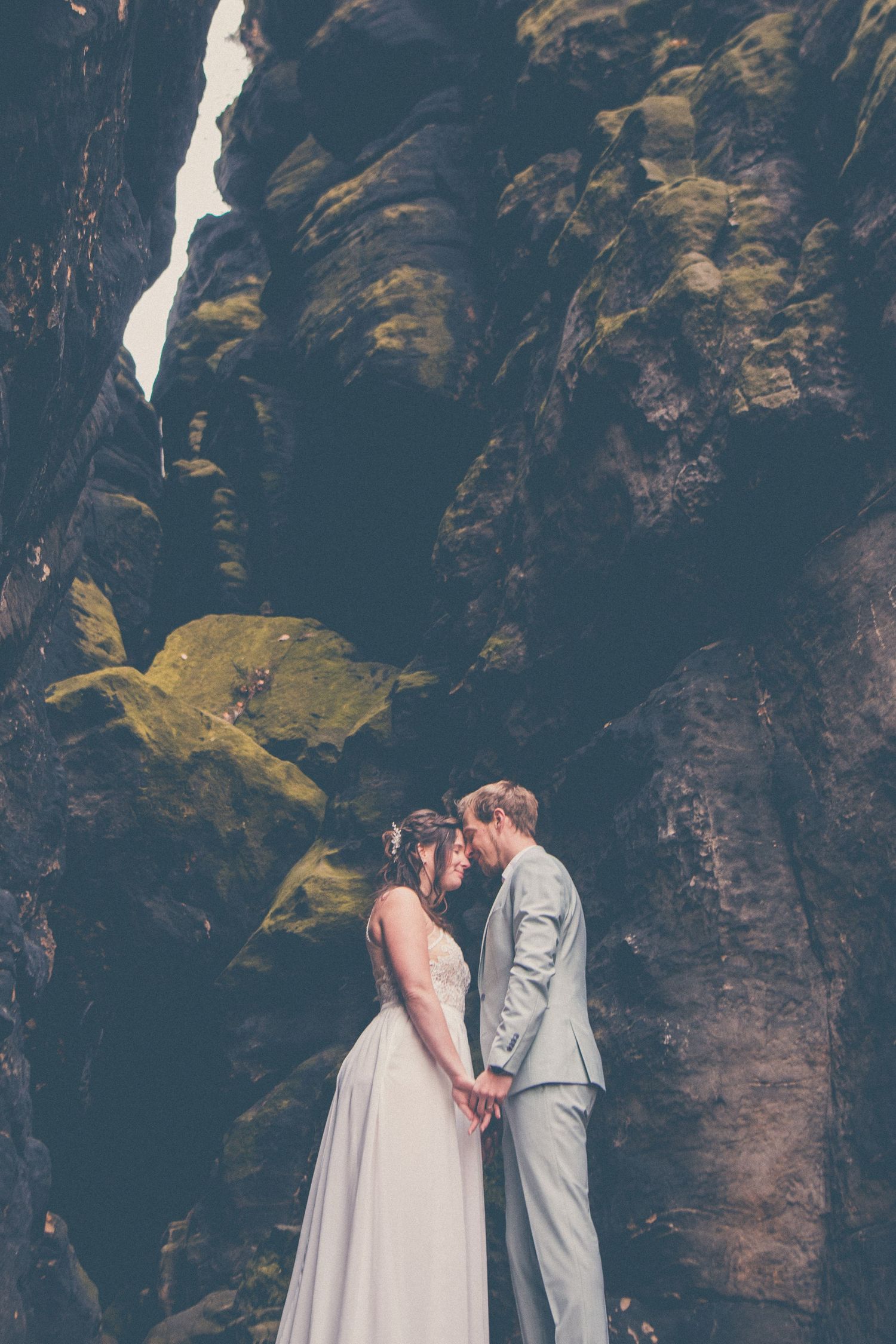 Wedding scene of happy couple laughing together in rustic brick venue.