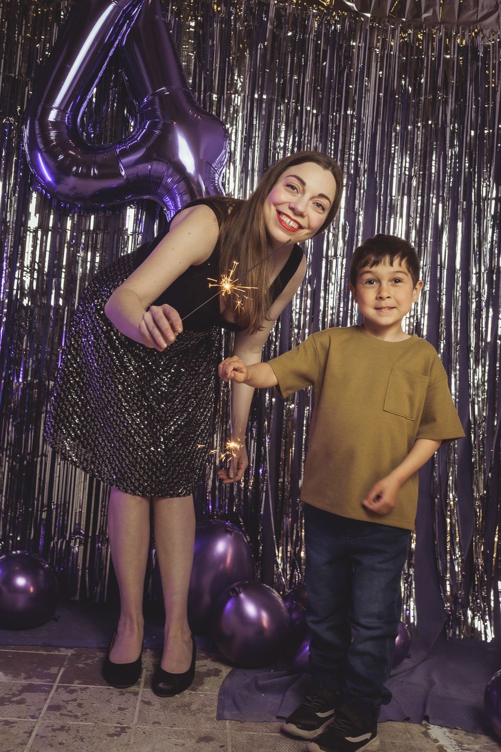 Playful moments captured against a sparkly silver tinsel backdrop with purple lighting effects.