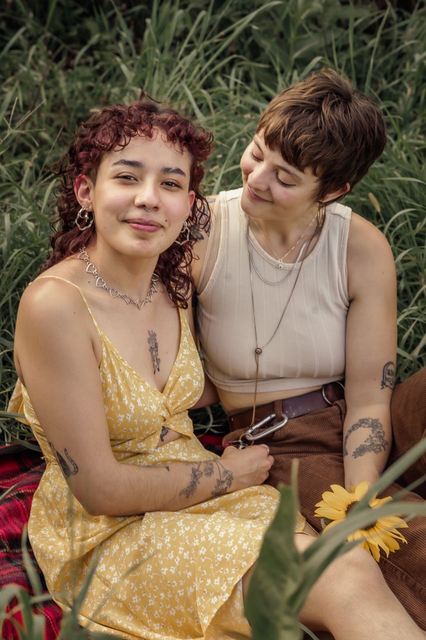 A couple shares intimate moments while sitting in a sunflower garden.