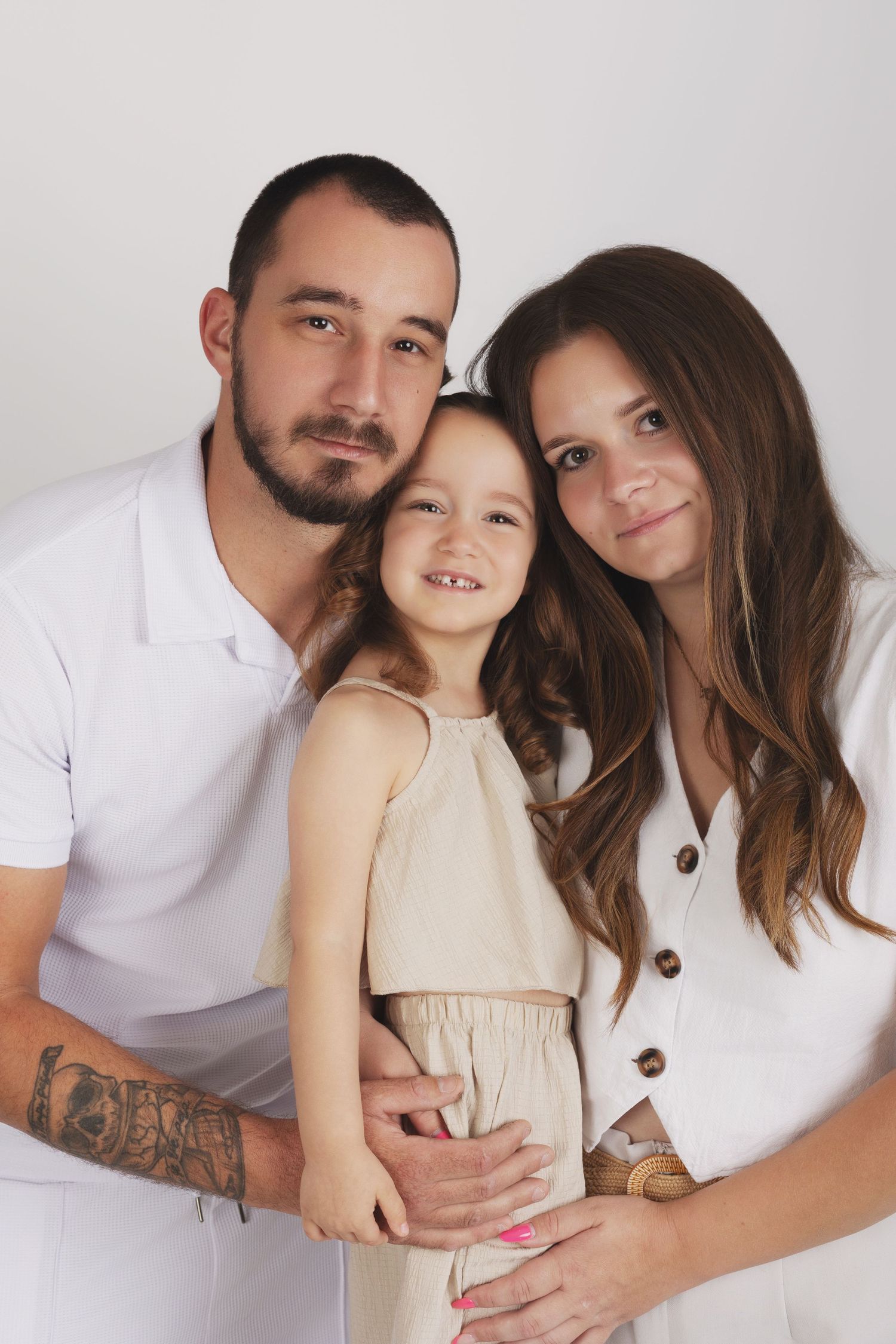 Family portrait against white background with group wearing formal attire in pastel colors.