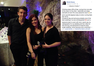 Three people posing together at a dimly lit indoor event or party.