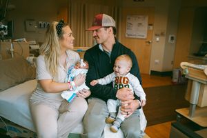 Parents share tender moments with their newborn baby in a hospital room setting.