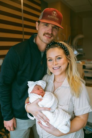 New parents in a hospital room share tender moments with their newborn baby.