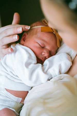 Intimate close-up shots of a sleeping newborn baby wrapped in white.