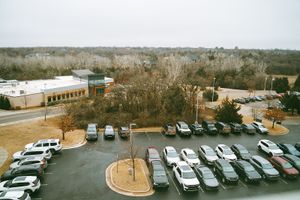 Aerial view of hospital parking lot with cars parked in rows.