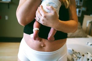 Close-up of hands holding a small baby bottle during feeding time.