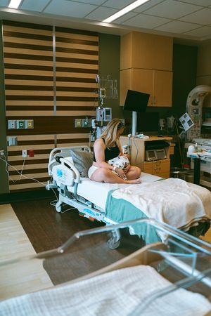 Hospital room with medical equipment and a bed featuring modern decor and striped wall panels.