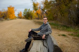 Boise Senior photos Boise white water park boy sitting on log bench