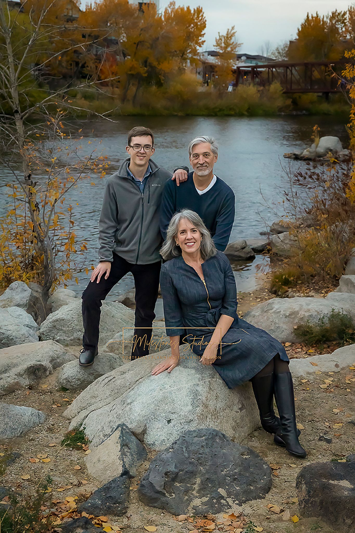 Boise Senior photos Boise white water park family of three posing on rocks of riverbank
