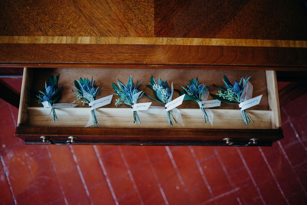 Decorative paper cranes hang in rows from wooden beams against a dark rustic background.
