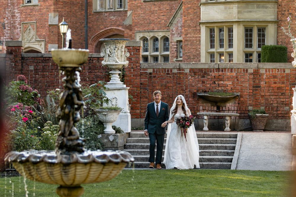 Bride and father walk down isle at the thornewood castle wedding ceremony